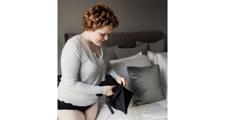 Teen placing period pants into dual compartment waterproof bag