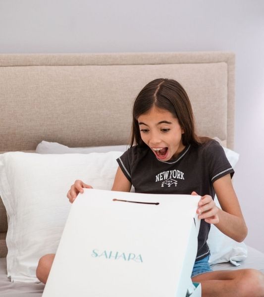 Girl excitedly opening first period gift box